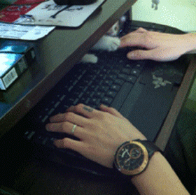 Chat jouant avec main et clavier d'ordinateur